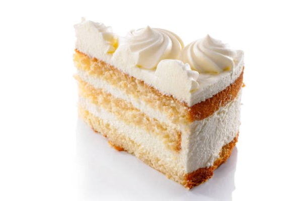 istockphoto-1307285636-612×612 slice of layered sponge cake with whipped cream decoration close-up isolated on white background